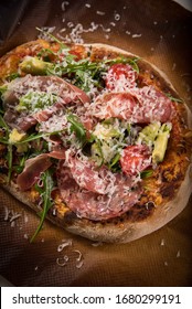 Pizza With Fresh Avocado, Rocketsalad, Salami And A Lot Of Parmesan Cheese