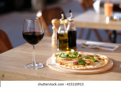 Pizza And Glass Of Red Wine In Outdoor Restaurant