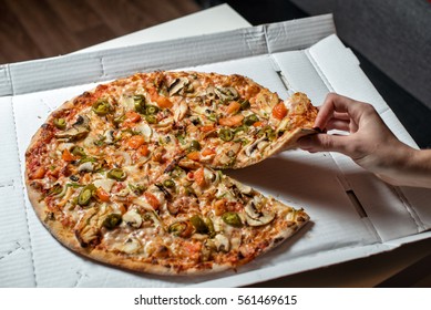 Pizza With Jalapeno Peppers. In The Hand A Slice Of Pizza