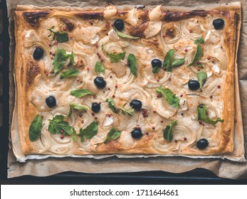 Pizza Made Of Puff Pastry With Onion, Chees, Olive, Pink Pepper And Feta Cheese Or Sheep's Cheese On Rustic Baking Paper - Top View, Clean Eating