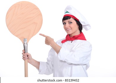 Pizza maker pointing to a pizza peel