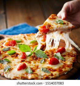 Pizza Margherita on black stone background, top view. Pizza Margarita with Tomatoes, Basil and Mozzarella Cheese close up. - Powered by Shutterstock