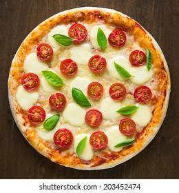 Pizza Margherita on dark wooden background top view