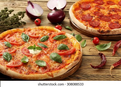  pizza margherita and pepperoni on rustic background
