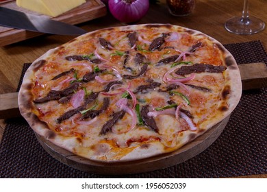 Pizza with mozzarella cheese, hot pepper, red onion and roast beef strips "pizza de arrachera"