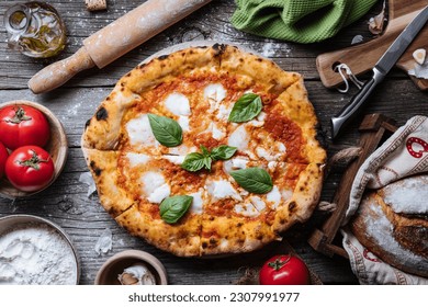 Pizza Napoletana, traditional and authentic Italian pizza baked in wood fired oven. Margherita pizza with mozzarella cheese, tomato sauce, olive oil and basil leaves. On wooden board with ingredients. - Powered by Shutterstock