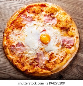 Pizza O Sole Mio With Baked Egg And Ham. Italian Pizza On Wooden Table Background