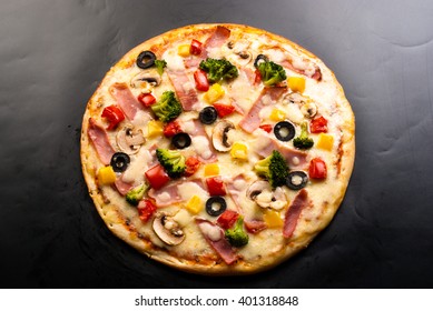Pizza On A Dark Background With Ham, Mushrooms, Cheese, Cauliflower, Olives And Sweet Pepper Top View