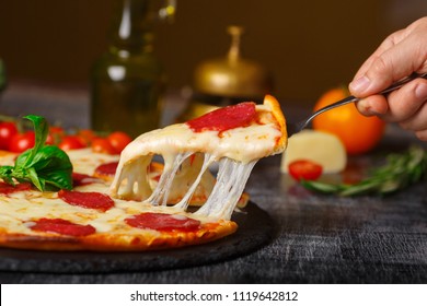 pizza on the table stretching cheese with cut couscous, side view - Powered by Shutterstock