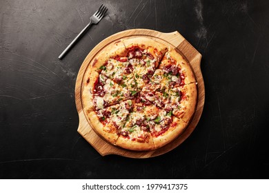 Pizza On A Wooden Base On A Black Textured Background Top View