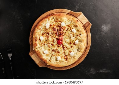 Pizza On A Wooden Base On A Black Textured Background Top View