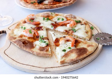 Pizza on a wooden board with mozzarella, mini arugula. - Powered by Shutterstock