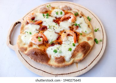 Pizza on a wooden board with mozzarella, mini arugula. - Powered by Shutterstock