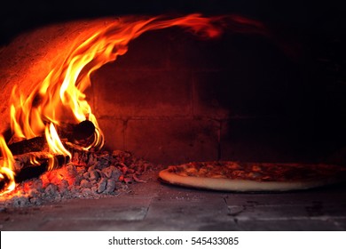 Pizza in pizza oven heated by wood 