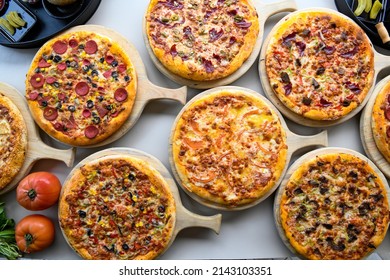 Pizza Party Dinner. Flat-lay Of Various Kinds Of Pizza Over Table, Top View, Wide Composition. Fast Food Lunch, Celebration, Gathering Concept.