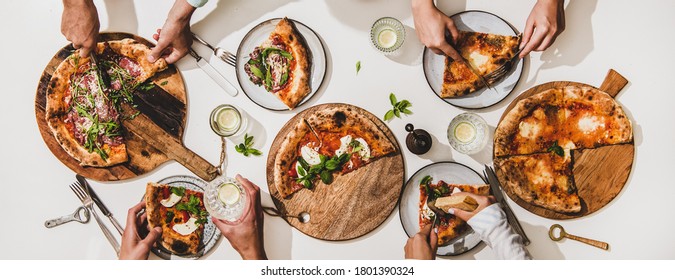 Pizza Party For Friends Or Family. Flat-lay Of Various Pizzas, Drinks And Peoples Hands Eating Pizza Over Plain White Table Background, Top View. Fast Food, Comfort Food, Italian Cuisine Concept