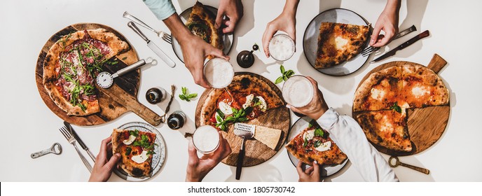 Pizza Party For Friends Or Family. Flat-lay Of Various Pizzas, Drinks And People Celebrating With Beer Over Plain White Table Background, Top View. Fast Food, Comfort Food, Italian Cuisine Concept