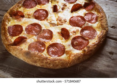 Pizza Pepperoni On Wooden Table Close Up