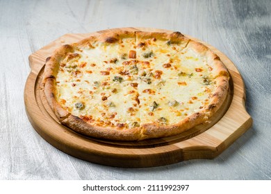 Pizza Quattro formaggi on wooden board on grey table