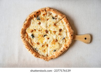 Pizza quattro fromaggi on a wooden board. Four Cheese Pizza or Quattro Formaggi Pizza topped, gorgonzola on wooden background.  - Powered by Shutterstock