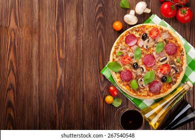 Pizza And Red Wine On Wooden Table Background. Top View With Copy Space