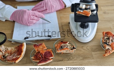Pizza samples are examined under a microscope in a food safety lab at a research facility
