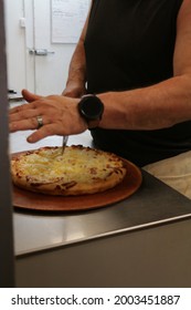 Pizza Shop Owner Cutting Pizza Before Delivery