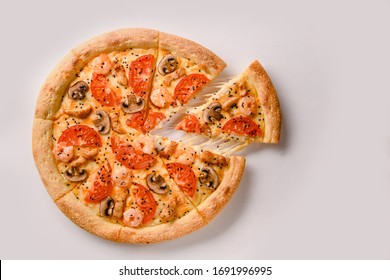 pizza with shrimp and mushroom and slice with stretching cheese.Top view
