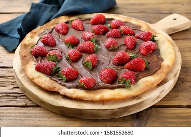 pizza strawberry and chocolate on rustic chopping board