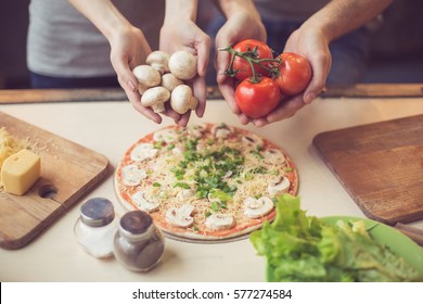 Pizza Time. Close Up Photo Of Hands Holding Mushrooms And Tomatoes. Young Couple In Kitchen. Family Of Two Preparing Food. Couple Making Delicious Pizza