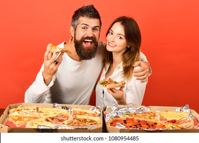 Pizza Time. Fast Food. Loving Couple Enjoying Pizza. Man And Woman Eating Pizza. Romantic Couple - Bearded Man Hugs His Girlfriend, Eating Pizza. Dating. Happy Family Time. Isolated On Red Background.