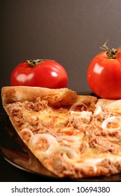 Pizza with tomatoes on a black background.