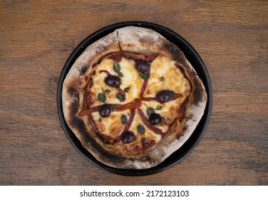 Pizza. Top View Of A Pizza With Mozzarella Cheese, Grilled Red Bell Peppers, Ham, Black Olives And Fresh Oregano Leaves, In A Pizza Pan On The Wooden Table. 