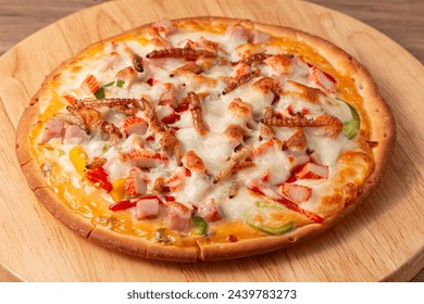 Pizza topped with bamboo worm, pupa, silkworm edible insect crispy mixed with sausage slices, sweet pepper and mozzarella cheese, Fried insects are the most widely sold street food in Thailand.