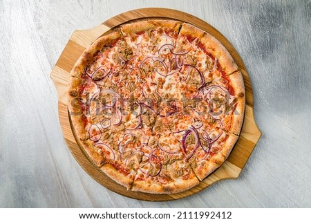Pizza with tuna and red onion on the board on grey table top view