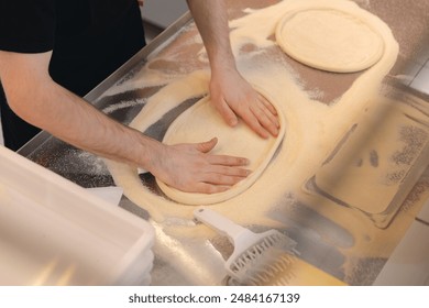 Pizzamaker stretches dough, worker preparing fresh food pizza. Business pizzeria concept. - Powered by Shutterstock