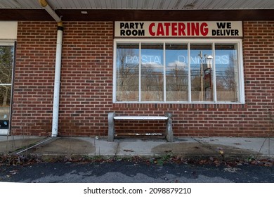 A Pizzeria At An Old Abandoned Strip Mall With Several Red Brick Store Fronts And Bench Closed After Long Struggle To Stay Open.