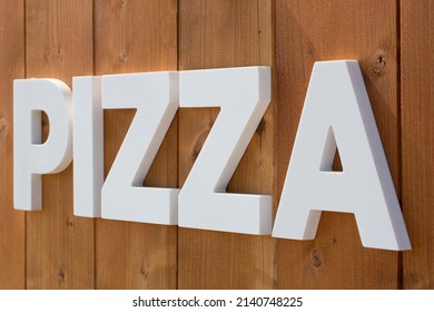 Pizzeria Sign Against A Wooden Background