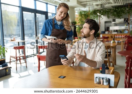 Pizzeria worker taking order from the client and looking friendly