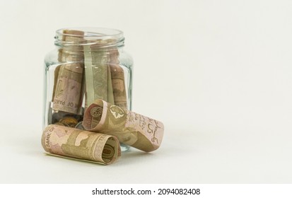 Pkr 10 Pakistani Rupees Currency Bank Notes With A Glass Jar On A White Background 