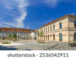 Place de la Revolution square, Museum of Fine Arts and Archeology building and green trees in Besancon old town centre ville, Besançon city historic centre, Bourgogne-Franche-Comte region, France