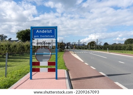 Place name sign for the village of Andelst, municipality of Overbetuwe, the Netherlands, with the text 'welcome' below on a sunny day