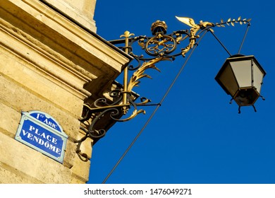 Place Vendôme. With Old Golden Lamp Post In The Blue Sky. White And Blue Street Name Plate. Paris, France. November 2018.