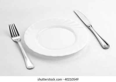Place Setting For One Person. Knife, White Plate And Fork.