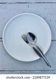 Place The Spoon And Fork On The Plate When You're Done Eating. Top View. Top View Of Plate, Spoon And Fork.