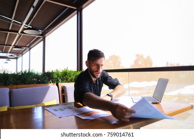 Placeman Sorting Papers On Desk Near Laptop. Strong Male Hands With Watch Near Window. Concept Of Stopping Document Clutter On Workplace.