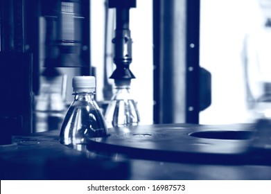 Placing Caps On Water Bottles At Bottling Plant