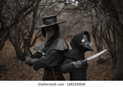 Plague Doctors In The Middle Ages Forest Pose With Medical Instruments