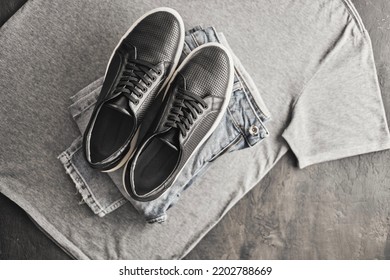 Plaid Grey Shirt, Jeans And Black Leather Sneakers On Wooden Background. Male Casual Outfit. Men's Fashion.