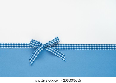 Plaid Ribbon Tied In A Bow On White And Blue Background